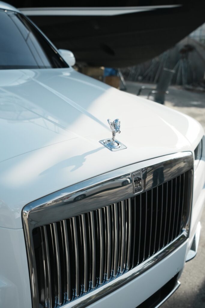 A close up of the hood and grill on a white car.