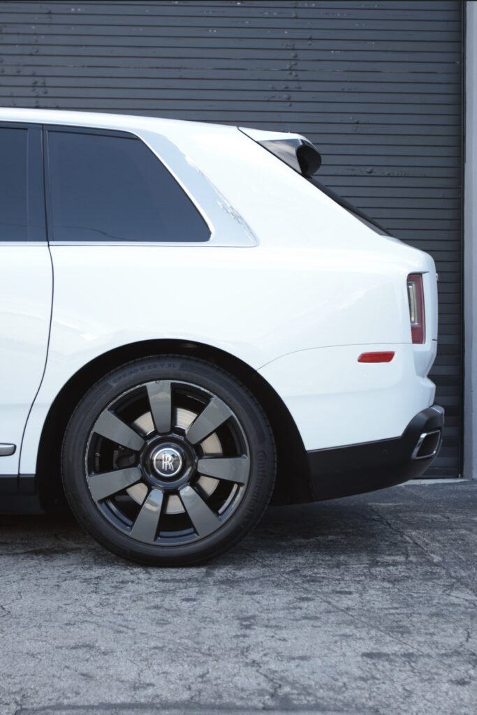 A white suv parked in front of a garage.